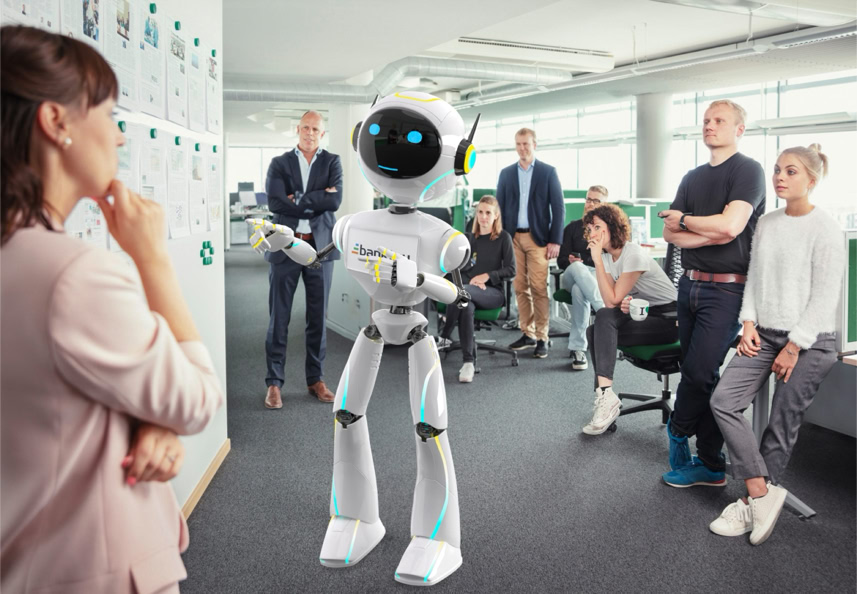 A group of people in an office setting are gathered around a humanoid robot, with one person standing near a whiteboard.